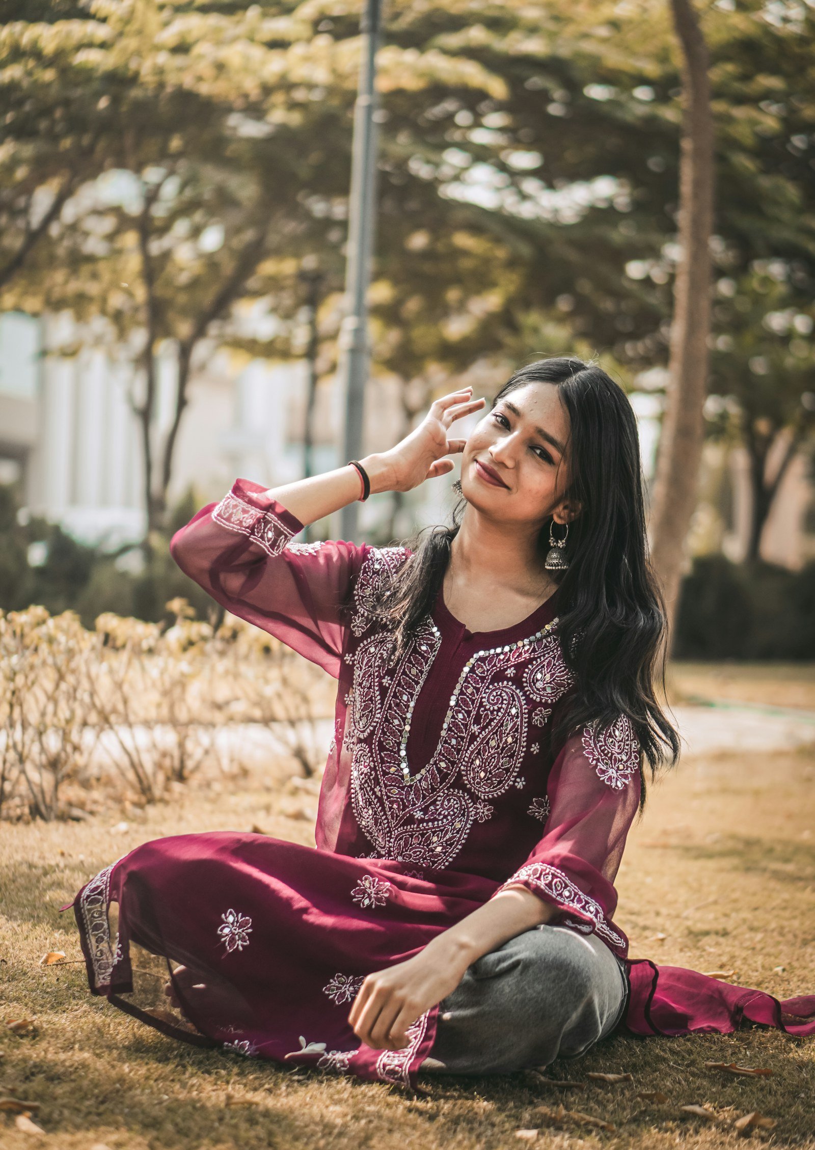 Woman in a maroon kurta relaxing outdoors