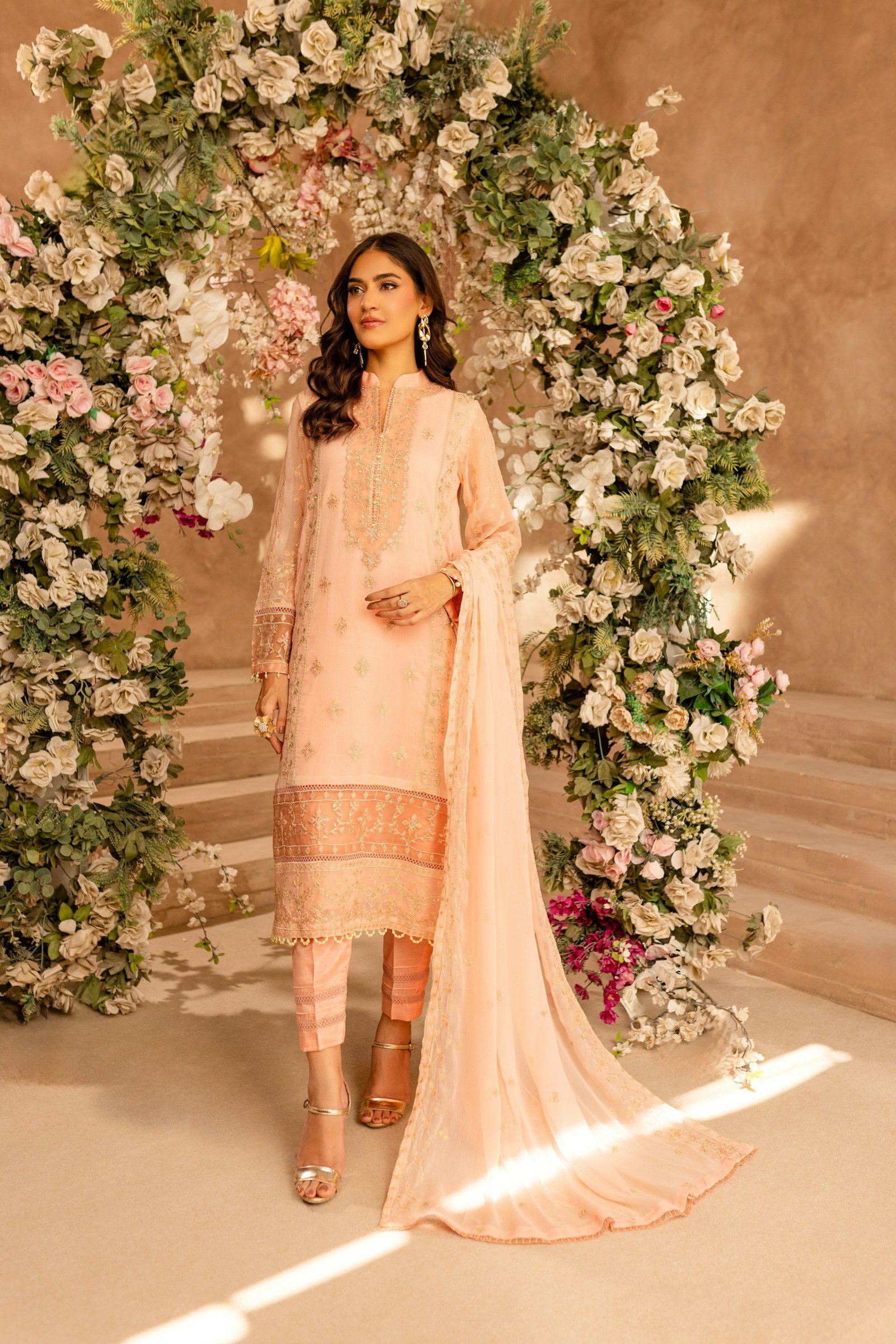 Model in a soft peach embroidered suit