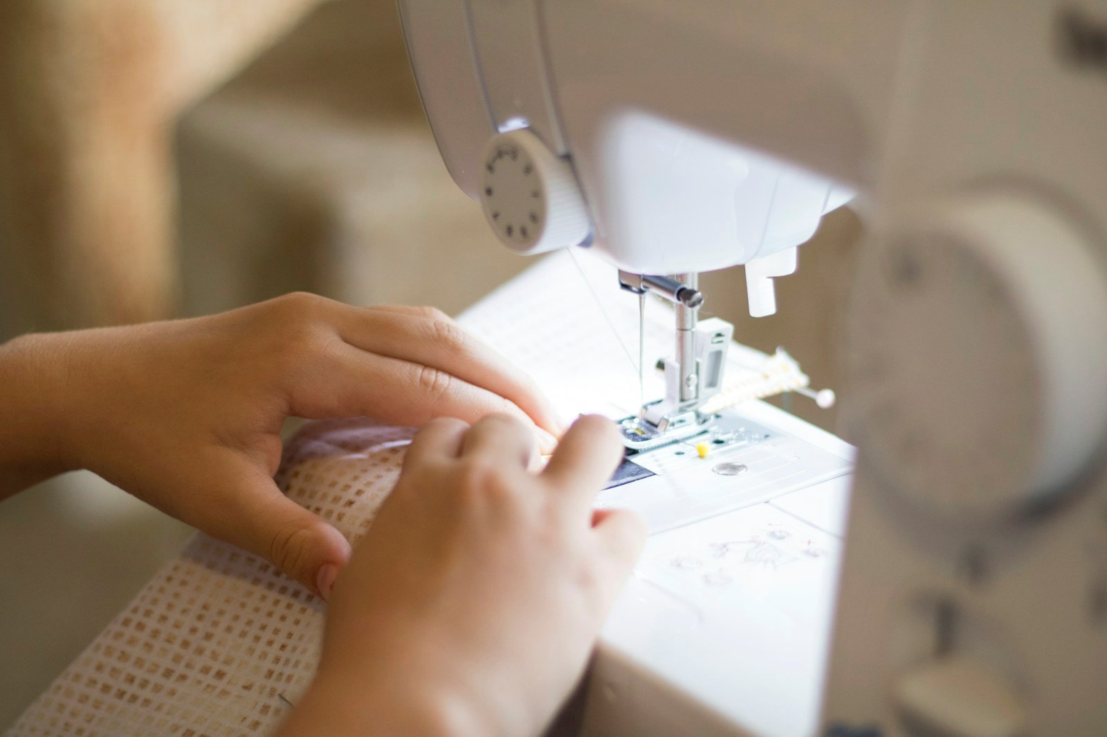 Hands guiding fabric through a sewing machine
